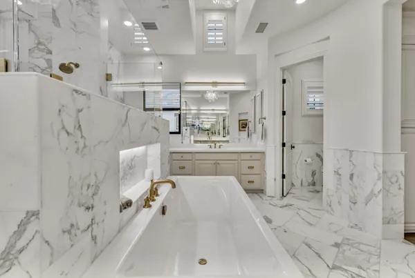 Experience luxury real estate photography showcasing a stunning marble bathroom with gold fixtures in a Gilbert, AZ property.