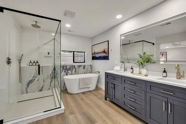 This modern bathroom in Scottsdale, AZ showcases sleek design with a marble tub, glass shower, and elegant fixtures, ideal for real estate photography.