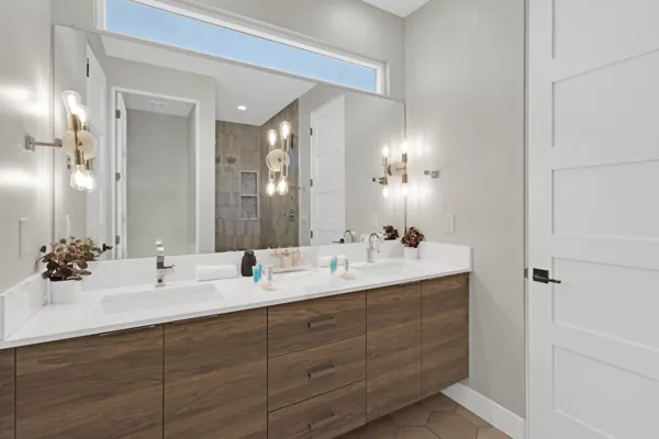 This modern bathroom in Scottsdale, AZ features a double sink vanity with wood cabinetry and elegant lighting, captured with professional real estate photography.