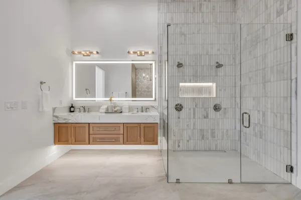 This stunning modern bathroom in Scottsdale, AZ, showcases exceptional real estate photography with its sleek glass shower and elegant vanity.