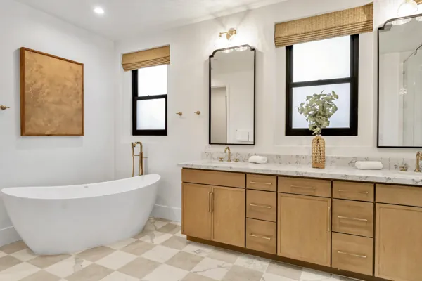 This bright bathroom in Scottsdale, AZ features a double vanity, freestanding tub, and elegant decor, showcased through professional real estate photography.