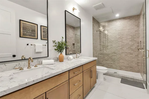 This modern bathroom in Scottsdale, AZ features a double sink with marble countertops and a walk-in shower, perfect for comfortable living as captured in this real estate photography.