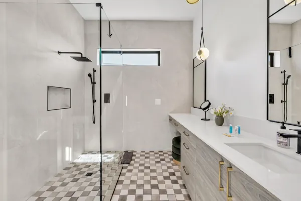 This modern bathroom in Scottsdale, AZ features a sleek shower and stylish vanity, captured beautifully for real estate photography to showcase its elegant design and bright ambiance.
