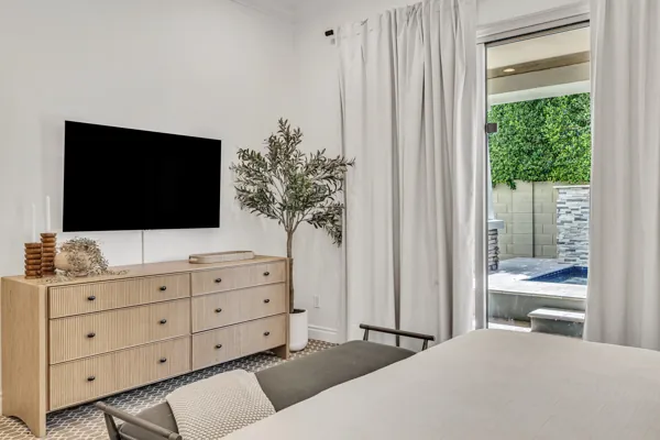This exquisite real estate photography showcases a beautifully designed bedroom in Mesa, AZ, featuring modern decor and poolside access.