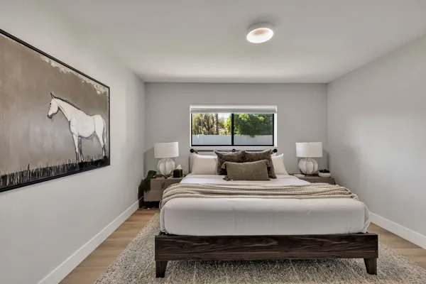 This minimalist bedroom in Scottsdale, AZ showcases modern real estate photography highlighting natural light and tasteful decor.
