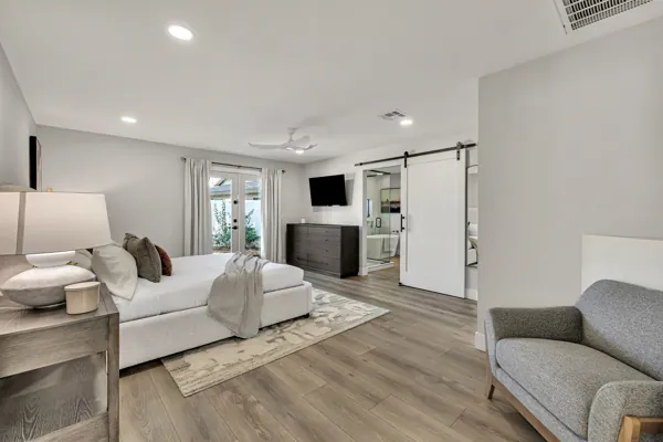 This Scottsdale, AZ home features a spacious bedroom with a stylish sliding door and elegant decor, highlighting the allure of real estate photography.
