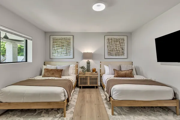 This real estate photography image from Scottsdale, AZ, showcases a modern bedroom with two beds and stylish decor, highlighting the serene atmosphere of the property.