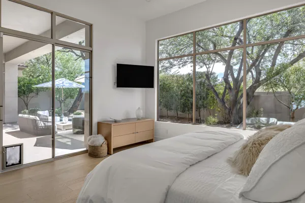 This stunning bedroom in Scottsdale, AZ, showcases elegant real estate photography with a view of a serene outdoor patio.