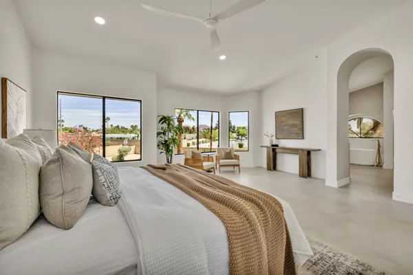 This spacious bedroom with large windows offers stunning views and natural light, showcasing modern real estate photography in Scottsdale, AZ.