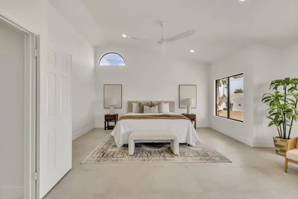This minimalist bedroom in Scottsdale, AZ features modern decor and abundant natural light, showcased through expert real estate photography for a stylish and inviting home.