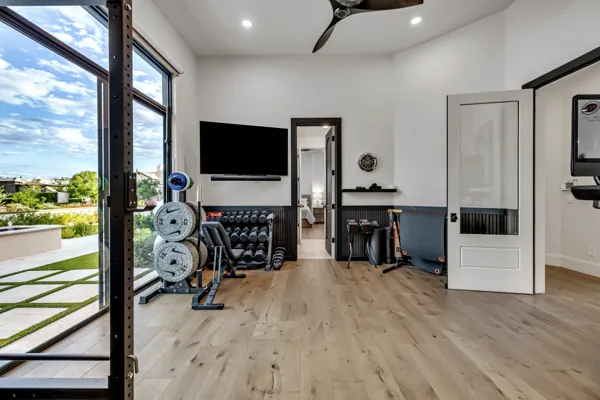 This luxury real estate photography showcases a modern home gym with scenic views in Gilbert, AZ.