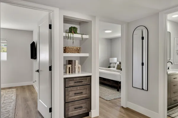 This Scottsdale, AZ home features a stylish hallway showcasing elegant shelving and a view into a modern bedroom, captured expertly in real estate photography.
