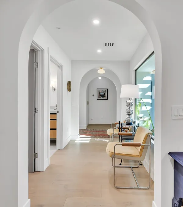 This luxury real estate photography showcases a beautifully designed hallway with elegant archways and modern furnishings in Scottsdale, AZ.