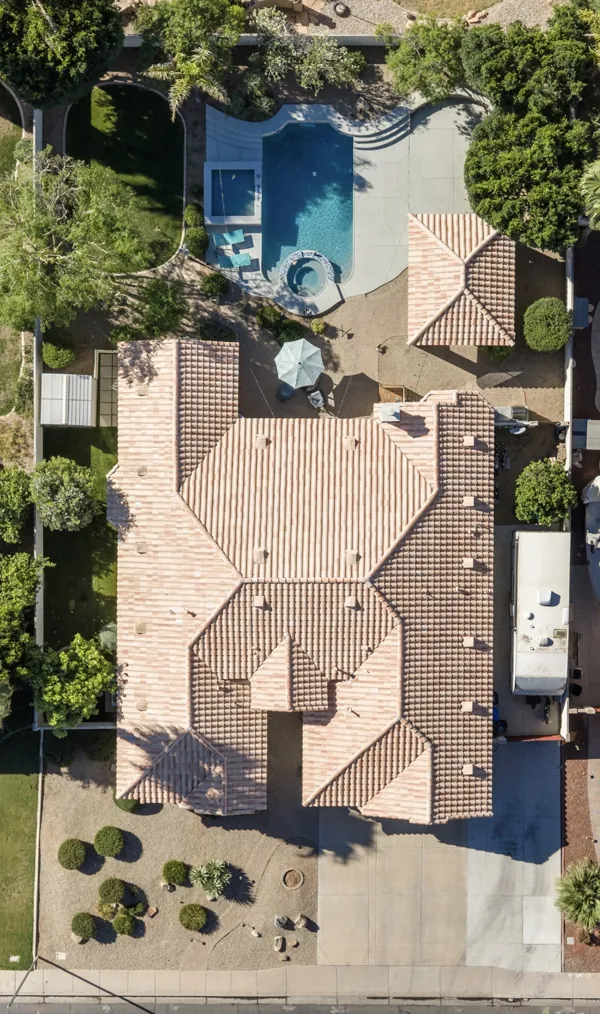Aerial real estate photography showcasing a tile roof home with a pool and yard in Gilbert, AZ, highlighting the property's spacious outdoor amenities and landscaping.