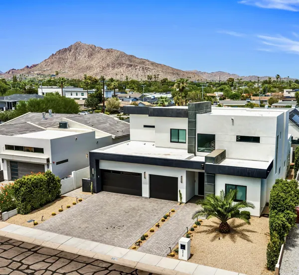 This modern home in Scottsdale, AZ features sleek architecture and a spacious driveway, captured beautifully in this real estate photography showcasing stunning exterior details and mountain views.