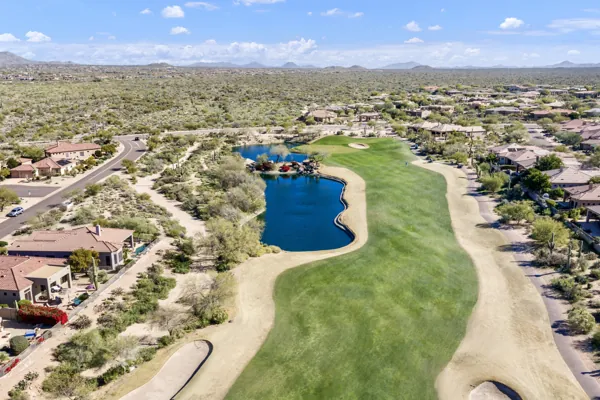 Aerial real estate photography showcasing a lush golf course and adjacent homes in Scottsdale, AZ, highlighting the beautiful desert landscape and well-maintained properties.