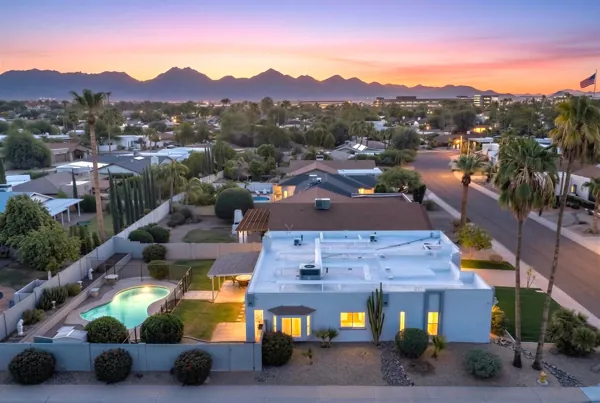 This twilight aerial view showcases beautiful residential homes with pools in Scottsdale, AZ, offering a serene neighborhood setting captured with expert real estate photography.
