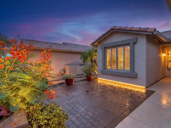 This stunning exterior patio in Chandler, AZ, showcases beautiful lighting and landscaping at sunset, captured perfectly with expert real estate photography.