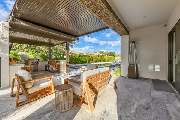 Explore this luxury real estate photography showcasing a stunning outdoor living area in Gilbert, AZ, featuring elegant patio seating and a picturesque pool view.