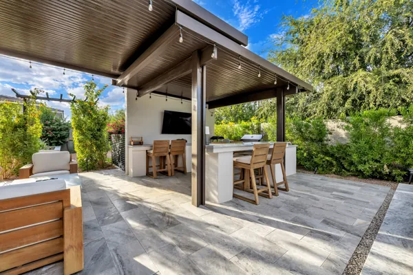 Experience luxury real estate photography showcasing a stunning outdoor kitchen and patio in Gilbert, AZ, highlighting modern design and lush landscaping.