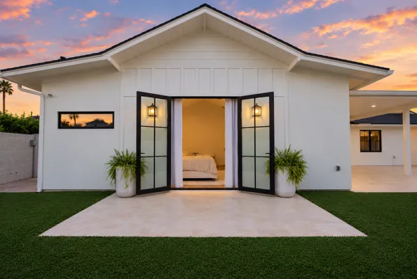 Experience luxury real estate photography showcasing a modern property on E Avalon Dr, Phoenix, AZ, highlighting elegant design with open French doors against a stunning sunset backdrop.