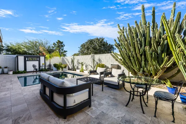 Experience luxury real estate photography showcasing an elegant outdoor patio in Scottsdale, AZ, featuring modern seating and vibrant cacti.