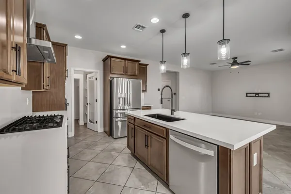 This stunning modern kitchen in Buckeye, AZ features sleek white countertops and stainless steel appliances, showcasing expert real estate photography.