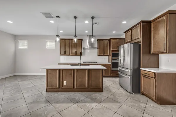 Explore this beautifully modern kitchen with wood cabinets and stainless steel appliances in Buckeye, AZ, showcasing premium real estate photography.