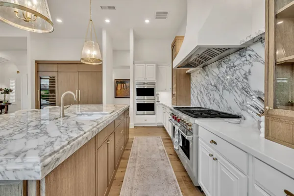 Explore this luxury real estate photography highlighting a stunning kitchen with marble countertops in Gilbert, AZ.