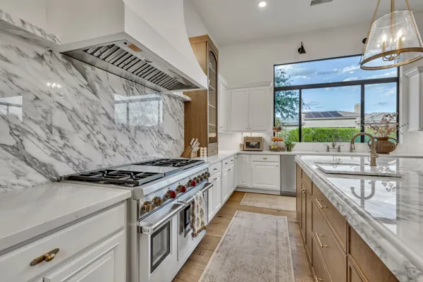 This luxury real estate photography captures a stunning modern kitchen in Gilbert, AZ, featuring exquisite marble countertops and high-end appliances.