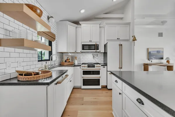This luxury real estate photography showcases a modern kitchen with white cabinetry and sleek design in Phoenix, AZ.