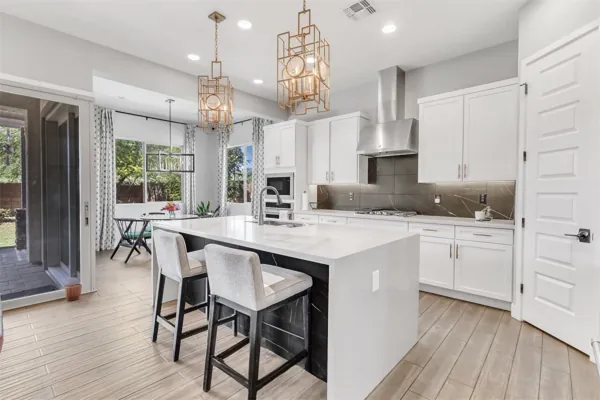 Bright modern kitchen with island and bar stools in a Phoenix, AZ home, showcased with professional real estate photography for a stylish and welcoming interior.