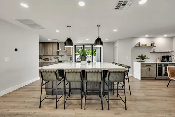 Experience exquisite real estate photography showcasing a modern kitchen in Scottsdale, AZ, featuring elegant lighting and stylish bar stools.