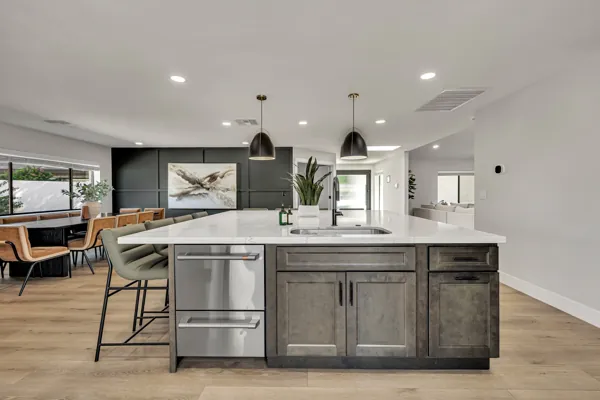 Beautiful modern kitchen with large island and dining area captured in real estate photography, showcasing elegant design in Scottsdale, AZ.