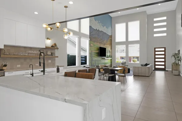 This spacious modern open-plan kitchen and living room features high ceilings and large windows in Scottsdale, AZ, captured with expert real estate photography to highlight its stylish design and natural light.