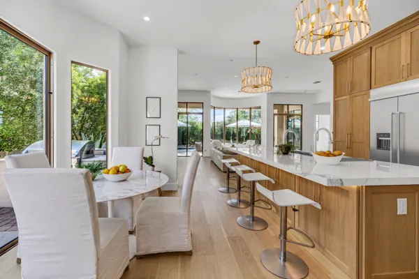 This stunning modern kitchen and dining area in Scottsdale, AZ, highlights exceptional real estate photography with its elegant design and bright ambiance.