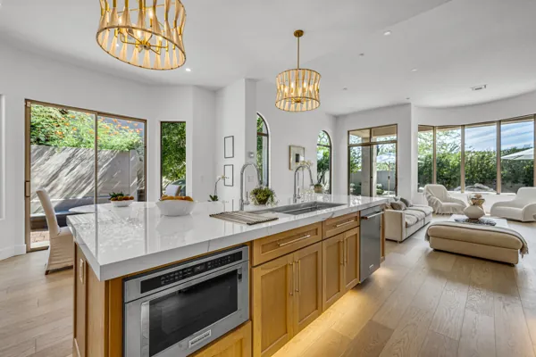 Explore the stunning real estate photography of a modern home in Scottsdale, AZ, showcasing an open kitchen and living area with elegant design and natural light.