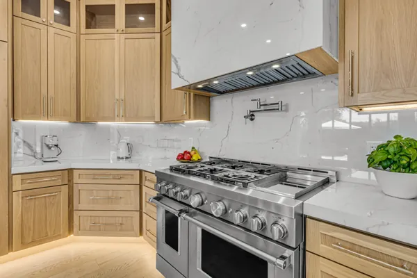 This real estate photography showcases a modern kitchen in Scottsdale, AZ featuring sleek wood cabinets and stainless steel appliances, offering a luxurious and functional space.