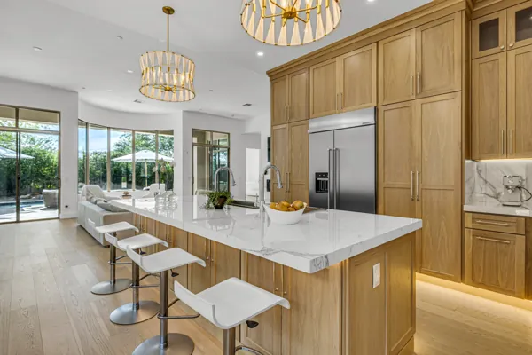 This stunning modern kitchen on E Caribbean Ln, Scottsdale, AZ, showcases elegant wood cabinetry and a spacious island, exemplifying premium real estate photography.