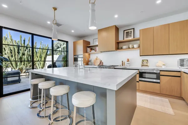This luxury real estate photography showcases a modern kitchen with marble countertops and wood cabinets in Scottsdale, AZ, offering a glimpse of high-end living.