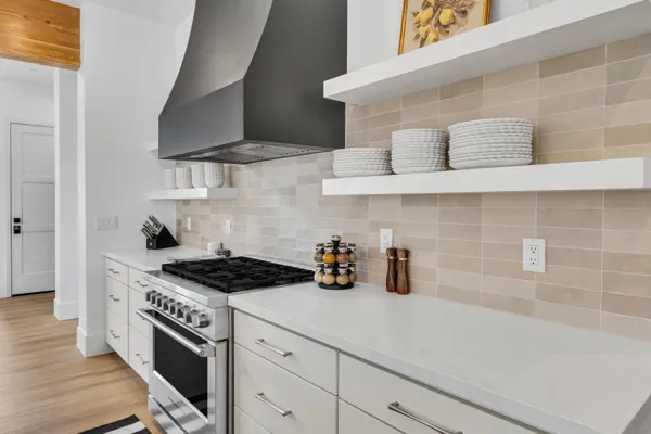 This modern kitchen in Scottsdale, AZ features sleek countertops and a stainless steel stove, captured with professional real estate photography to highlight its contemporary design.