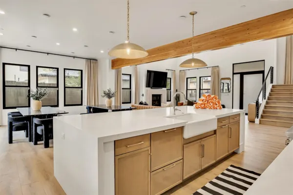 This modern kitchen with a spacious island and adjoining living room is beautifully captured in Scottsdale, AZ real estate photography, highlighting natural light and contemporary design.