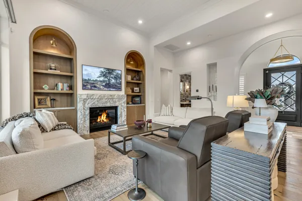 This luxury real estate photography showcases an elegant living room in Gilbert, AZ, featuring a stylish fireplace and modern decor.