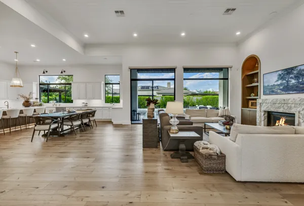 This luxury real estate photography showcases an elegant open-plan living space with a fireplace in Gilbert, AZ, highlighting modern interior design.