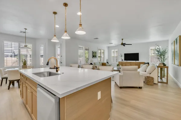 This modern open-concept kitchen and living room in Gilbert, AZ showcases elegant design and spacious comfort, captured through expert real estate photography in Morrison Ranch neighborhood.