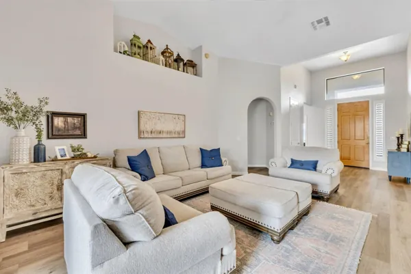 This bright living room with beige sofa set and high ceilings showcases elegant real estate photography in Goodyear, AZ.