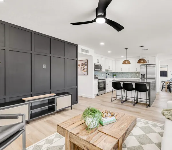 Bright modern living room and kitchen with stylish black accents and wood furniture showcased in this Mesa, AZ home real estate photography.