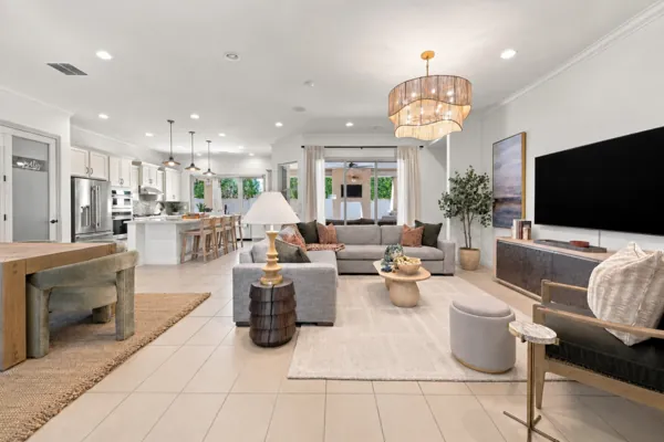This real estate photography showcases a spacious modern living room and kitchen in Mesa, AZ, highlighting stylish interior design and ample natural light.