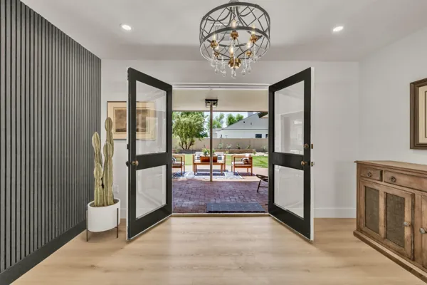 This Phoenix, AZ home features an inviting interior entryway with double doors opening to a charming patio, captured with expert real estate photography.