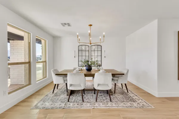 This bright dining room in Phoenix, AZ features modern furniture and elegant lighting, highlighting the home's spacious and inviting atmosphere through expert real estate photography.